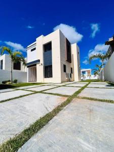 a white house with palm trees in front of it at Modern Villa in Punta Cana - Villa Moderna in Punta Cana