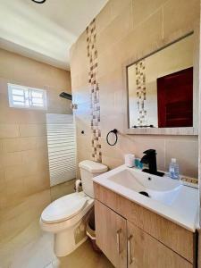 a bathroom with a toilet and a sink at Modern Villa in Punta Cana - Villa Moderna in Punta Cana