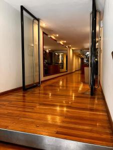 pasillo vacío con suelo de madera y puertas de cristal en Esme en Buenos Aires
