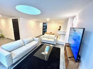 uma sala de estar com um sofá branco e uma televisão em C22-2 Hermoso departamento con Terraza em Cidade do México