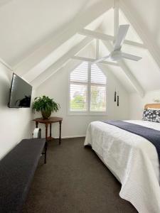 een slaapkamer met een bed en een plafondventilator bij The Loft Matua in Tauranga