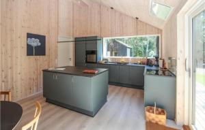a kitchen with gray cabinets and a large window at Lovely Home In Samsø With Wifi in Nordby