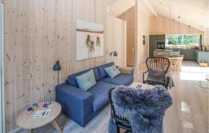een woonkamer met een blauwe bank en een tafel bij Lovely Home In Sams With Wifi in Nordby