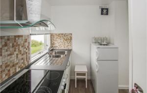 a small kitchen with a sink and a refrigerator at Udsigtspavillion in Kolby Kås