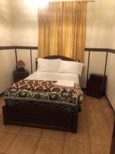 1 dormitorio con 1 cama grande con almohadas blancas en Hostal casa franciscana, en Quito