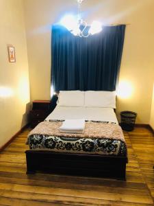 1 dormitorio con 1 cama con cortina azul en Hostal casa franciscana, en Quito