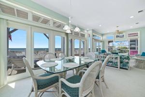a dining room with a glass table and chairs at Oceanfront/Zero Steps to Beach/Views/4BR in Gulf Shores