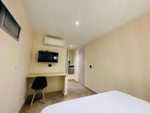 a bedroom with a bed and a tv on the wall at The Host at Santa Marta in Santa Marta