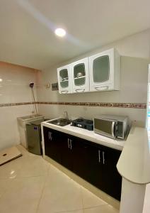 cocina con fregadero y microondas en La Marina -Apartamentos frente al mar, en Ríohacha