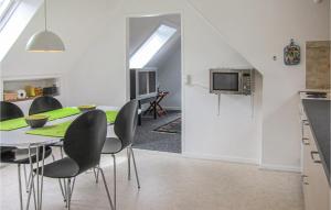 cocina y comedor con mesa y sillas en Pet Friendly Apartment In Gudhjem With House Sea View, en Gudhjem