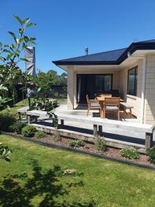 a patio with a table and benches in front of a house at 10 @ Wai Matangi in Turangi