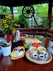 a wooden table with plates of food and cups of coffee at Casa Darul Bunicii in Breaza