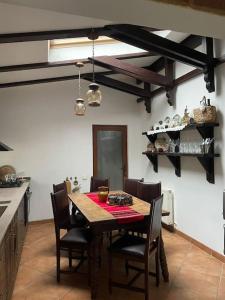 - une cuisine avec une table et des chaises en bois dans la chambre dans l'établissement Locuința extraodinară cu șemineu ,grădina , foișor, à Breaza