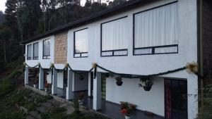 a white house with windows and plants on it at Casablanca Choachi in Choachí
