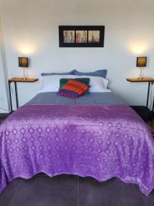 a purple blanket on a bed with two lamps at Casablanca Choachi in Choachí