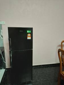 Un refrigerador negro con un cartel de comida rápida. en PCB PURPLE GUEST HOUSE, en Kota Bharu