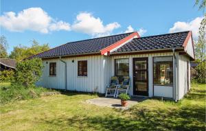 een klein wit huis met een veranda en een raam bij 2 Bedroom Nice Home In Sams in Kolby Kås