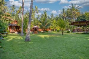a yard with palm trees and a house at Puri Yalus Bungalow in Nusa Penida