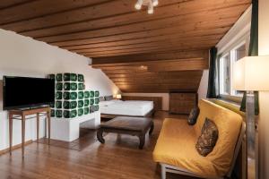 Zimmer mit einem Bett, einem Sofa und einem TV in der Unterkunft Sonnhof in Bad Ischl