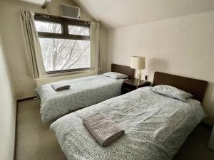 八幡平市にある19 Accommodationの窓のある部屋にベッドが2つある