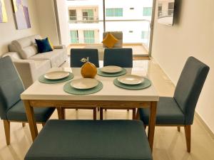 mesa de comedor con 4 sillas y sala de estar en Exclusivo Apartamento Frente Al Mar En Cartagena, en Cartagena de Indias