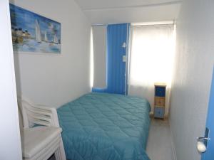 Un dormitorio con una cama azul y una ventana en Maison Les Sables-d'Olonne, 3 pièces, 4 personnes - FR-1-92-663, en Les Sables-dʼOlonne