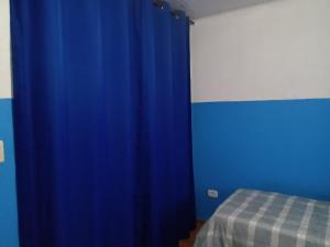 馬蒂尼奧斯的住宿－anderson，床上的蓝色窗帘