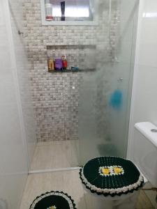 ducha con puerta de cristal y alfombra de ducha en anderson en Matinhos