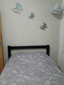 a bedroom with three butterflies on the wall at anderson in Matinhos