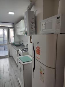 a kitchen with a white refrigerator and microwave at Amplio depto en PB con entrada independiente y doble cochera in Las Heras