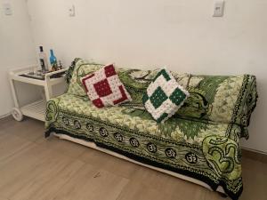 a couch with pillows on it in a living room at Kitnet Arembepe - Aconchego da Lulu in Arembepe