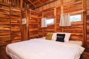 a bedroom with a bed in a log cabin at Urbanview Villa Kolopaking Kebumen by RedDoorz in Kebumen