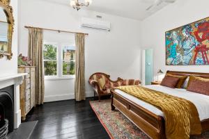 a bedroom with a king sized bed and a fireplace at WARATAH at Queenscliff in Queenscliff