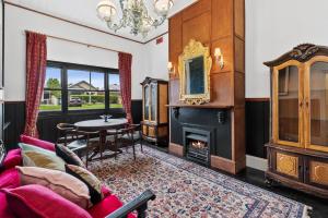 a living room with a fireplace and a table at WARATAH at Queenscliff in Queenscliff