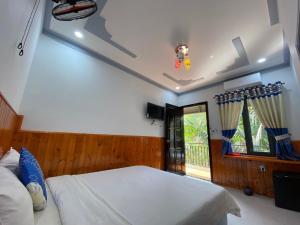 ein Schlafzimmer mit einem weißen Bett und einem Fenster in der Unterkunft Nhà nghỉ Cát Đằng Hồ Tràm in Hồ Tràm