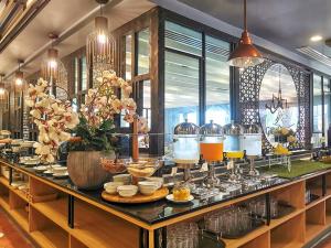 a buffet line with food and drinks on a table at Garden Cliff Resort And Spa in North Pattaya