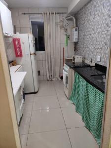 a small kitchen with a refrigerator and a stove at Ap Estacio in Rio de Janeiro