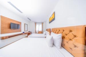 een hotelkamer met 2 bedden en een televisie bij Pandora Boutique Hotel - Managed by ATH in Da Nang