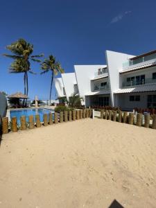 a building on the beach next to a resort at Maria Farinha Residence Prince - LocarHouse in Paulista