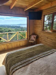 a bedroom with a bed and a large window at Turismo del Bosque in Castro