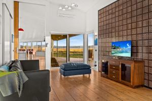 a living room with a couch and a flat screen tv at The Point Bass Coast in Bass