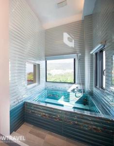 ein großes Bad mit einer Badewanne und einem Fenster in der Unterkunft Xiaoliuqiu 88 Homestay in Xiaoliuqiu