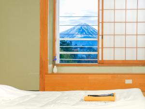富士河口湖町にある芙蓉山居煙霞ー元富士の屋旅館ーの山の景色を望む窓付きのベッド