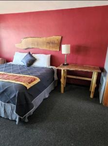 1 dormitorio con 1 cama y 1 mesa con lámpara en Tri-State Wood Inn, en Dickeyville