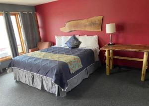 a bedroom with a bed and a red wall at Tri-State Wood Inn in Dickeyville