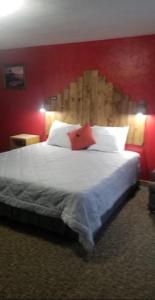 1 dormitorio con 1 cama grande y pared roja en Tri-State Wood Inn en Dickeyville