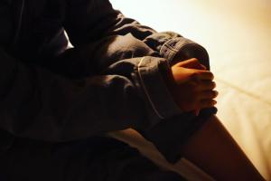 a person sitting down with their hands on their lap at まちの別邸 緝 shu in Kochi