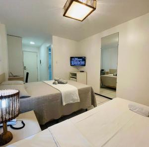 a hotel room with two beds and a television at Flat no Resort Gran Lençóis in Barreirinhas