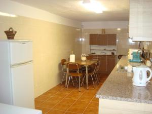cocina con mesa y nevera blanca en Villa T4 35km Montargil - Private & Heated Pool en Casal do Anafe de Baixo