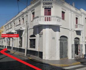 un edificio blanco con una flecha roja delante de él en HOSTAL espinoza, en Arequipa